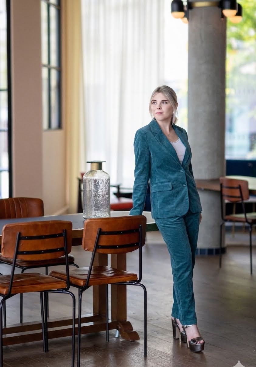 Abi Prendergast standing in a teal corduroy suit